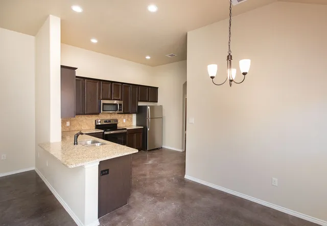 a kitchen with stainless steel appliances kitchen island granite countertop a sink and cabinets