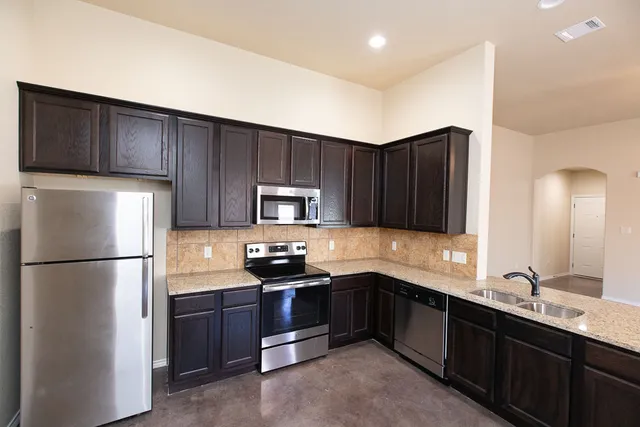 a kitchen with a sink a stove a refrigerator and cabinets