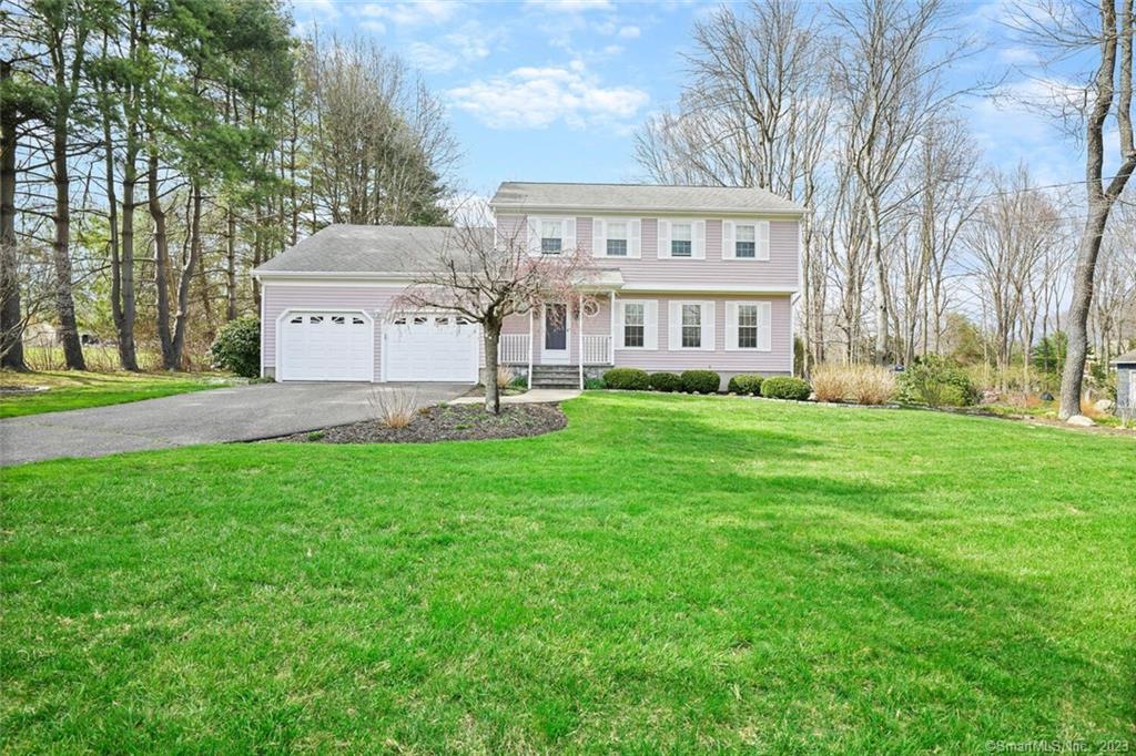 a front view of a house with a yard and trees