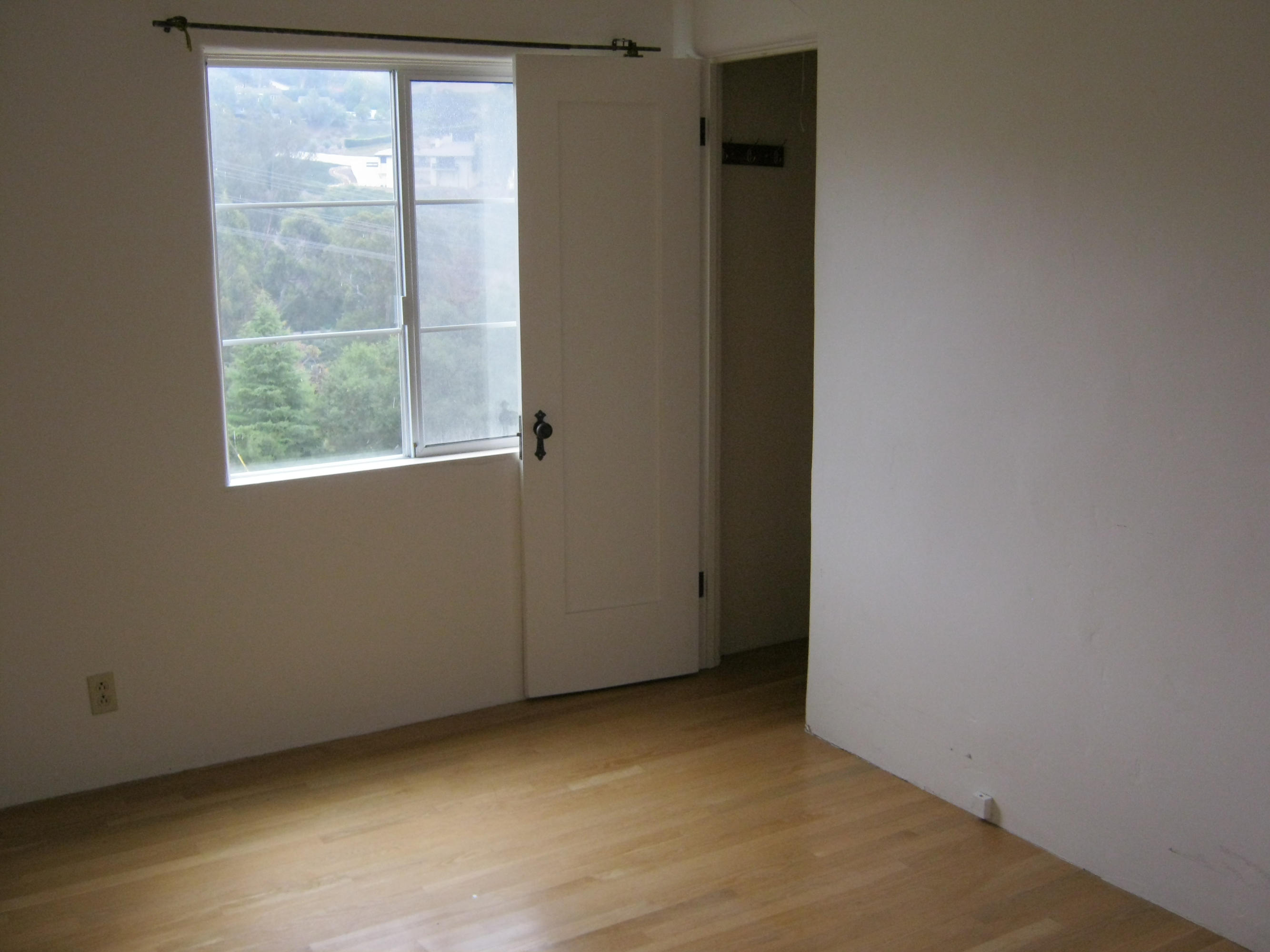 486 Conejo Road Santa Barbara, CA 93103 - Photo 7 of 11 an empty room with wooden floor and windows