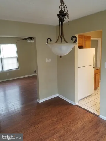 a view of empty room with wooden floor and window