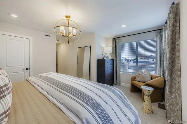 a bedroom with a bed and a chandelier