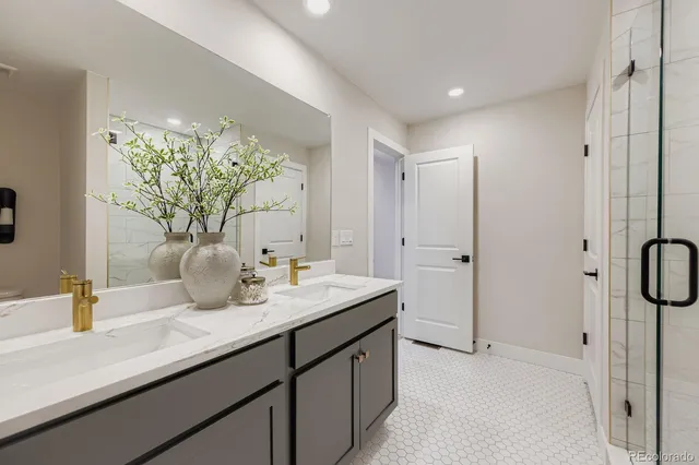 a bathroom with a granite countertop sink a mirror and a shower