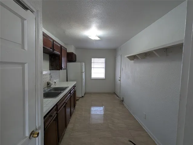a hallway with sink and mirror