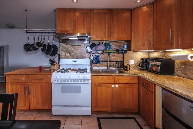 a kitchen with stainless steel appliances granite countertop a stove and a refrigerator