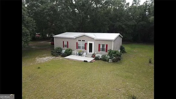 a front view of a house with yard patio and trees