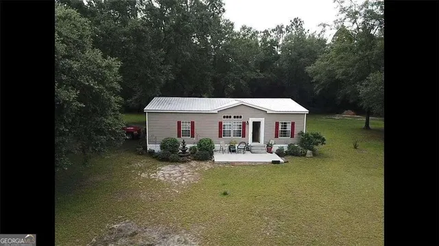 an aerial view of a house with garden space and lake view