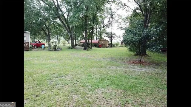 a view of a field with trees in the background