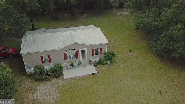 a view of house with backyard and outdoor seating