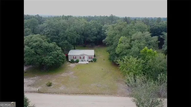 an aerial view of a house with swimming pool and sitting space