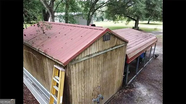 a view of a house with backyard and sitting area