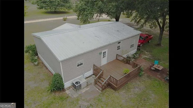 a view of backyard with potted plants and large tree
