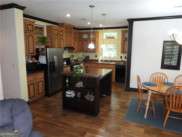 a kitchen with stainless steel appliances granite countertop a refrigerator a stove and a sink