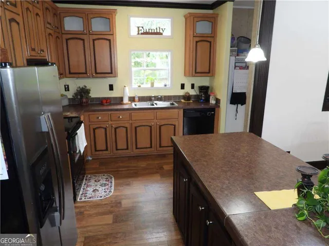 a kitchen with stainless steel appliances granite countertop a refrigerator a sink dishwasher stove and oven