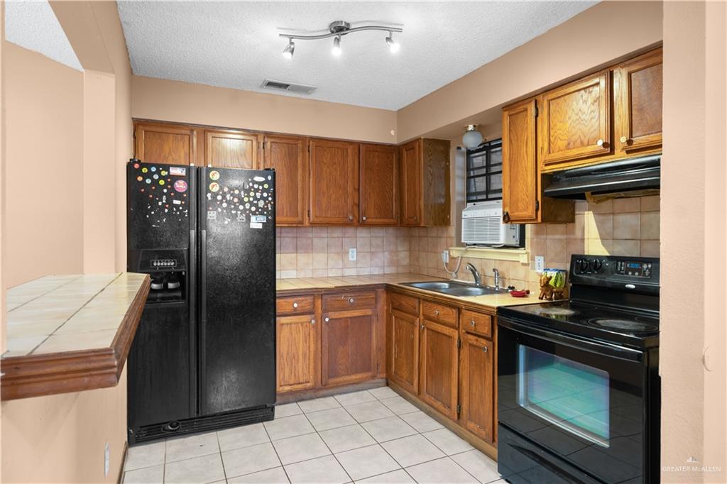 912 Rankin Street Mission, TX 78572 - Photo 5 of 17 a kitchen with stainless steel appliances granite countertop a refrigerator stove top oven and sink