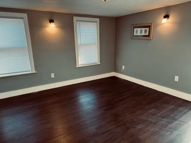 a view of a room with wooden floor and window