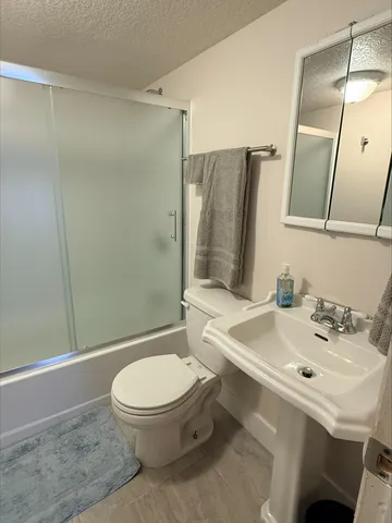 a bathroom with a sink toilet and shower