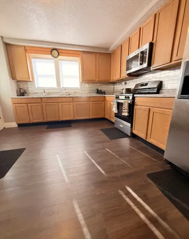 a kitchen with stainless steel appliances granite countertop a stove a sink and a microwave