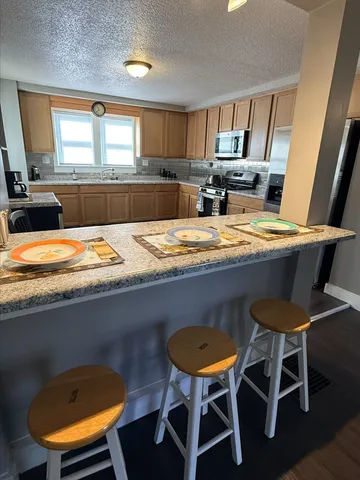 a kitchen with a table chairs and a refrigerator