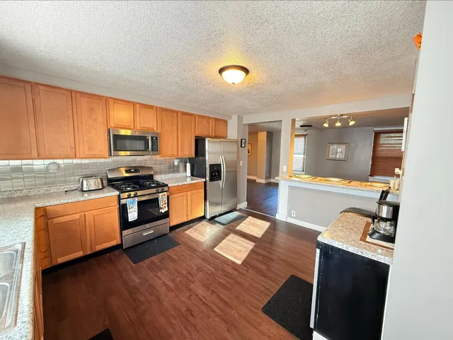 a kitchen with granite countertop a stove top oven and sink