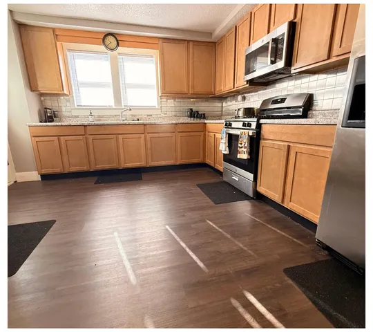 a kitchen with stainless steel appliances a stove a sink and a microwave