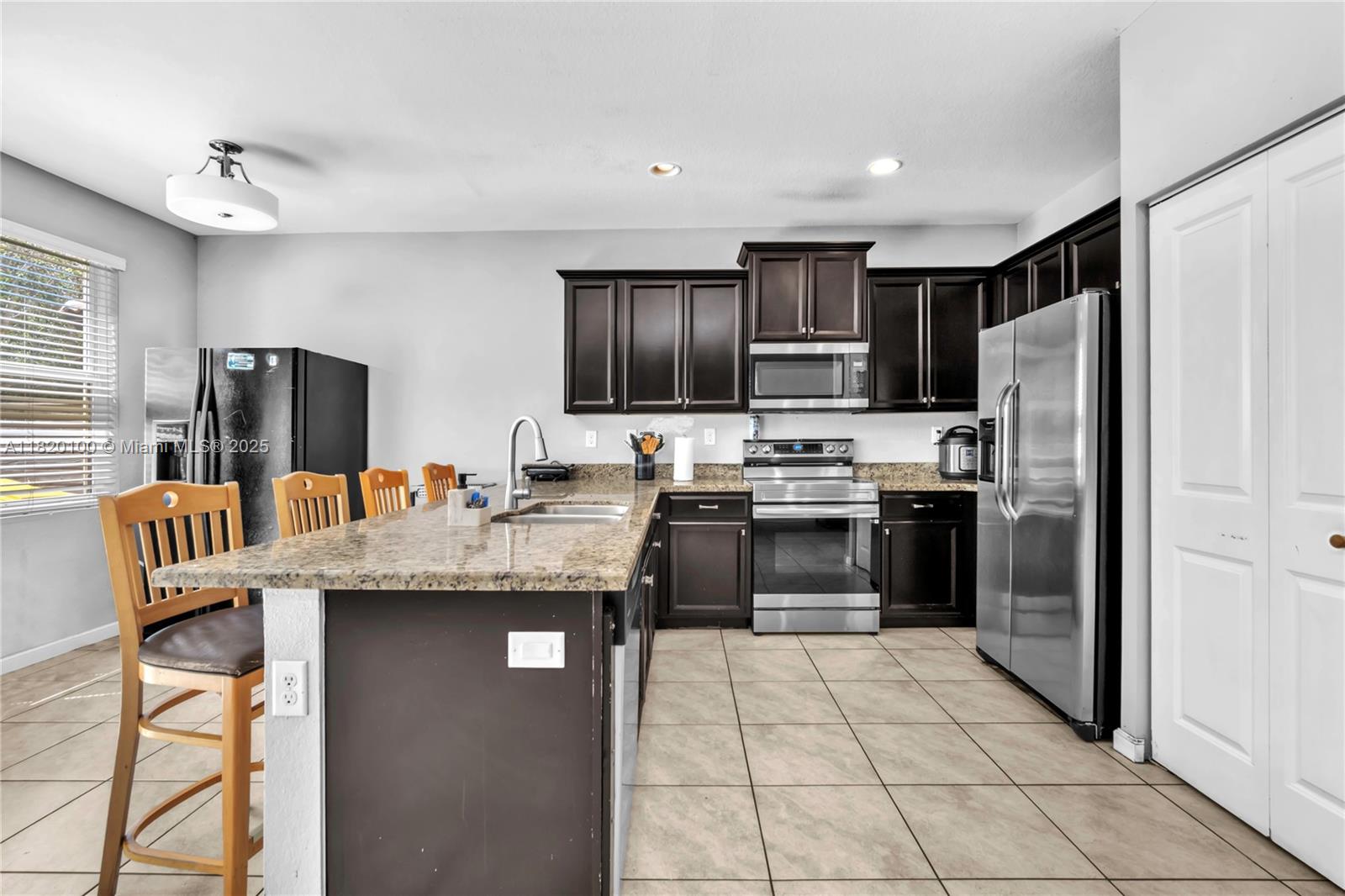 2190 Southeast 2nd Street Homestead, FL 33033 - Photo 11 of 37 a kitchen with stainless steel appliances granite countertop a refrigerator oven a sink dishwasher and white cabinets with wooden floor