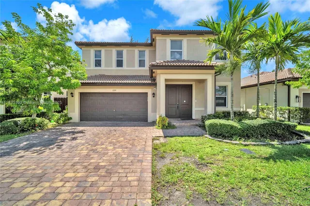 a front view of a house with a yard and garage