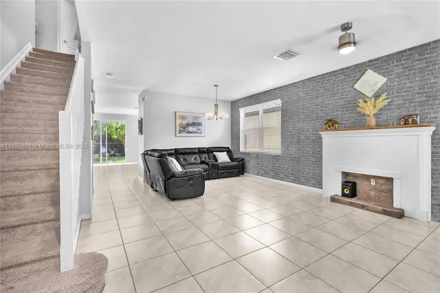 a spacious bedroom with a bed a fireplace and window