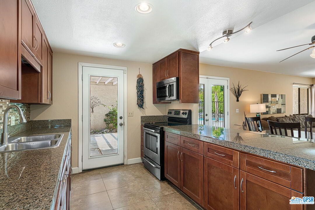 2783 North Cerritos Road Palm Springs, CA 92262 - Photo 16 of 25 a kitchen with stainless steel appliances granite countertop a refrigerator a stove top oven a sink and dishwasher