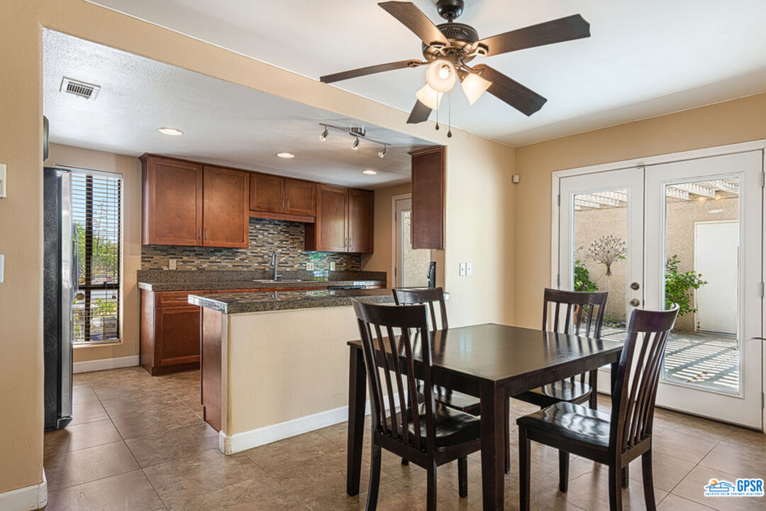 2783 North Cerritos Road Palm Springs, CA 92262 - Photo 18 of 25 a kitchen with stainless steel appliances granite countertop a dining table chairs refrigerator and cabinets