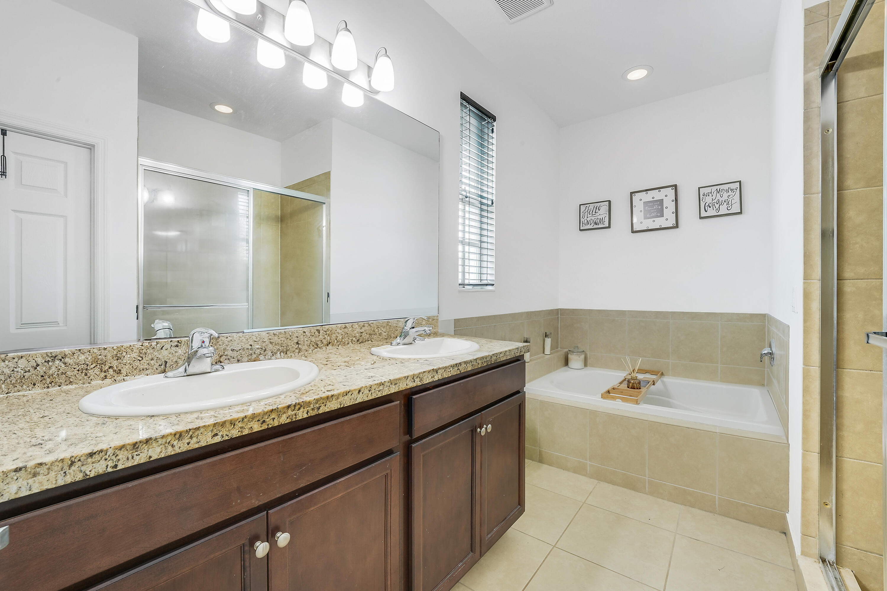 2900 Southwest 119th Way Miramar, FL 33025 - Photo 35 of 37 a bathroom with a granite countertop sink a large mirror and a bath tub