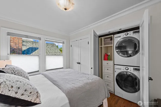 a bedroom with a bed and a washing machine in it