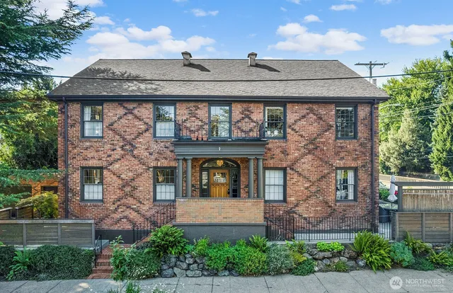 front view of a brick house with a small yard