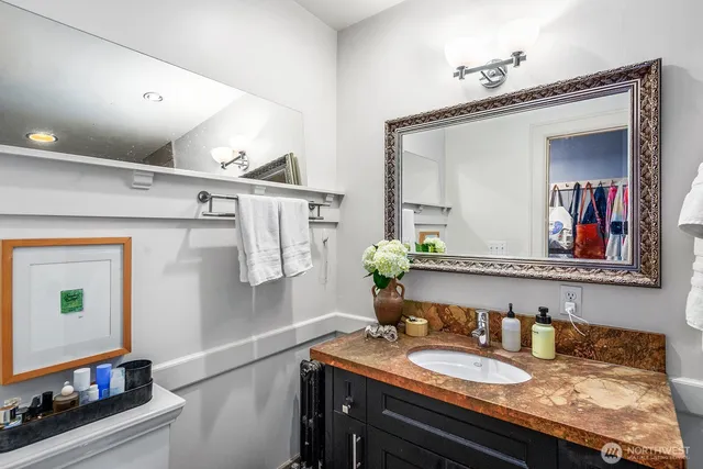 a bathroom with a granite countertop sink and a mirror