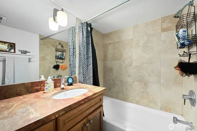 a bathroom with a granite countertop sink a toilet and shower