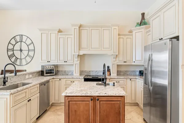 a kitchen with granite countertop a center island stainless steel appliances cabinets and a window