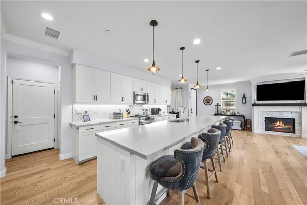 a large kitchen with sink a counter space appliances and cabinets