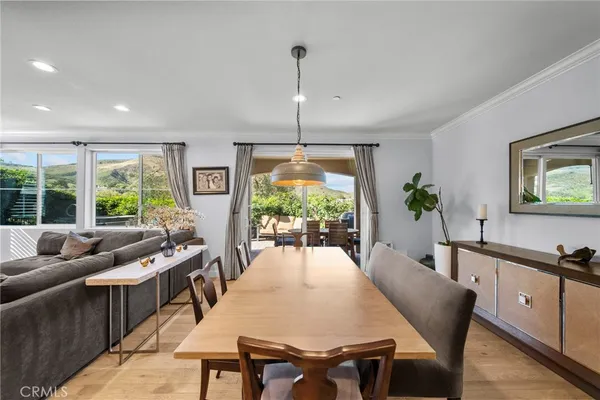 a dining room with furniture a chandelier and wooden floor