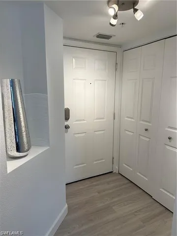 an empty room with wooden floor and closet