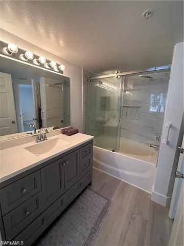 a bathroom with a double vanity sink a large mirror and a bathtub