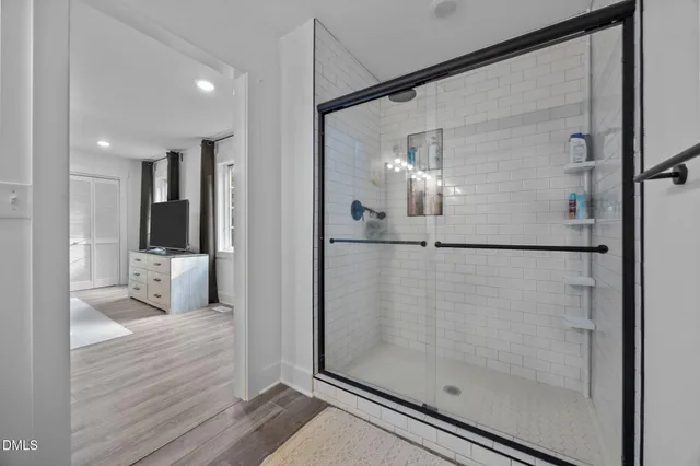 a bathroom with a glass shower door and a bathtub