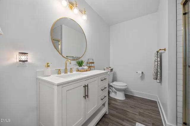 a bathroom with a toilet a sink and mirror