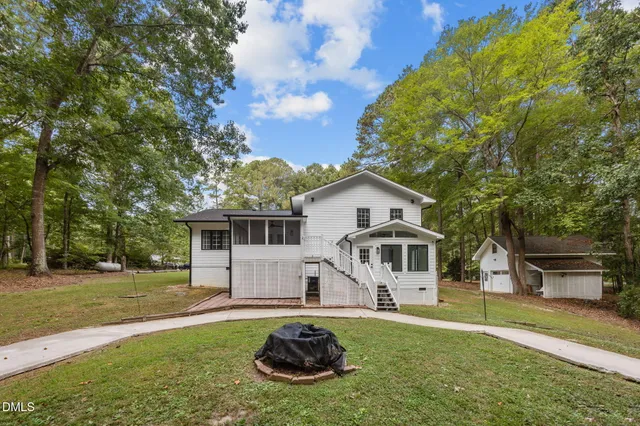 a view of a house with backyard and sitting area