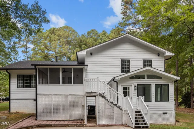 a white house covered with tall trees
