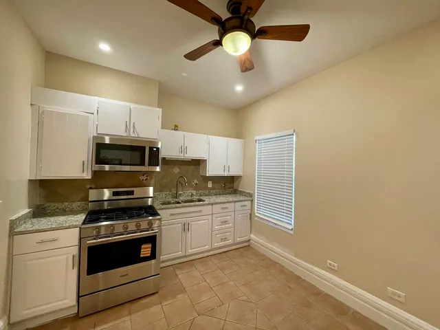 a kitchen with stainless steel appliances a stove sink microwave and cabinets
