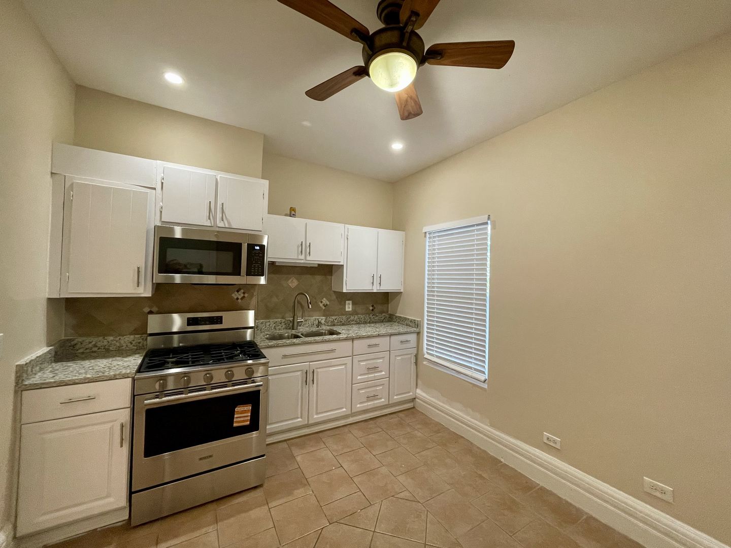 72 North 4th Street, Unit 4 Aurora, IL 60505 - Photo 2 of 11 a kitchen with stainless steel appliances a stove sink microwave and cabinets