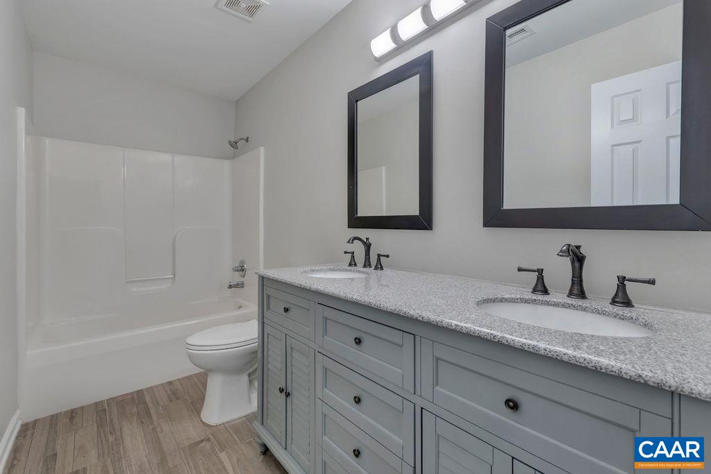 6807 Spring Hill Road Ruckersville, VA 22968 - Photo 30 of 37 a bathroom with a granite countertop toilet a sink and a mirror
