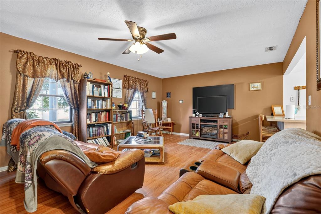 1925 Northwest 60th Avenue Ocala, FL 34482 - Photo 20 of 29 a living room with furniture ceiling fan and a flat screen tv
