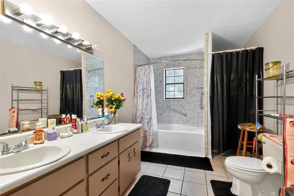 a bathroom with a double vanity sink toilet and shower