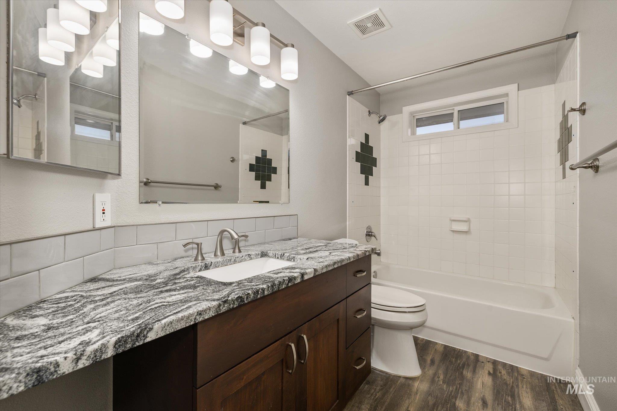 2870 North Morello Avenue Meridian, ID 83646 - Photo 11 of 20 Full bath featuring vanity, shower / washtub combination, and dark wood-style floors